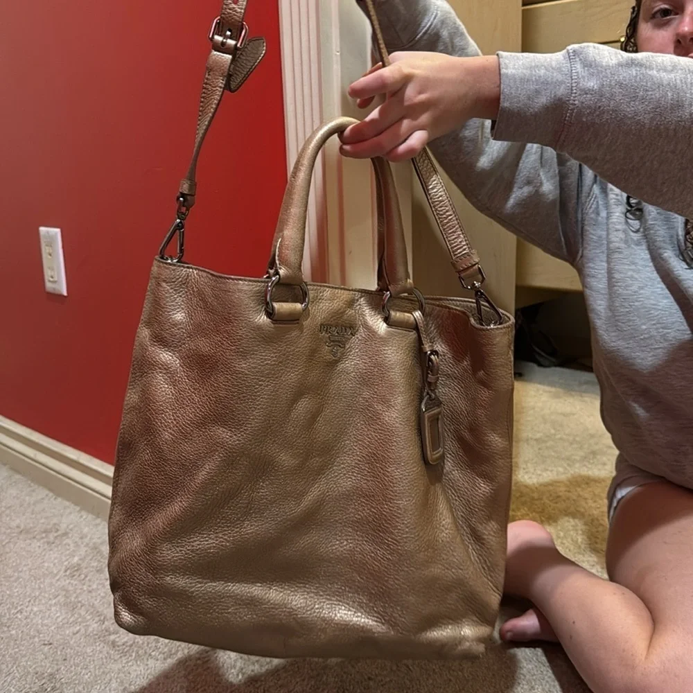 Prada tote bag with detachable crossbody strap in gold leather.